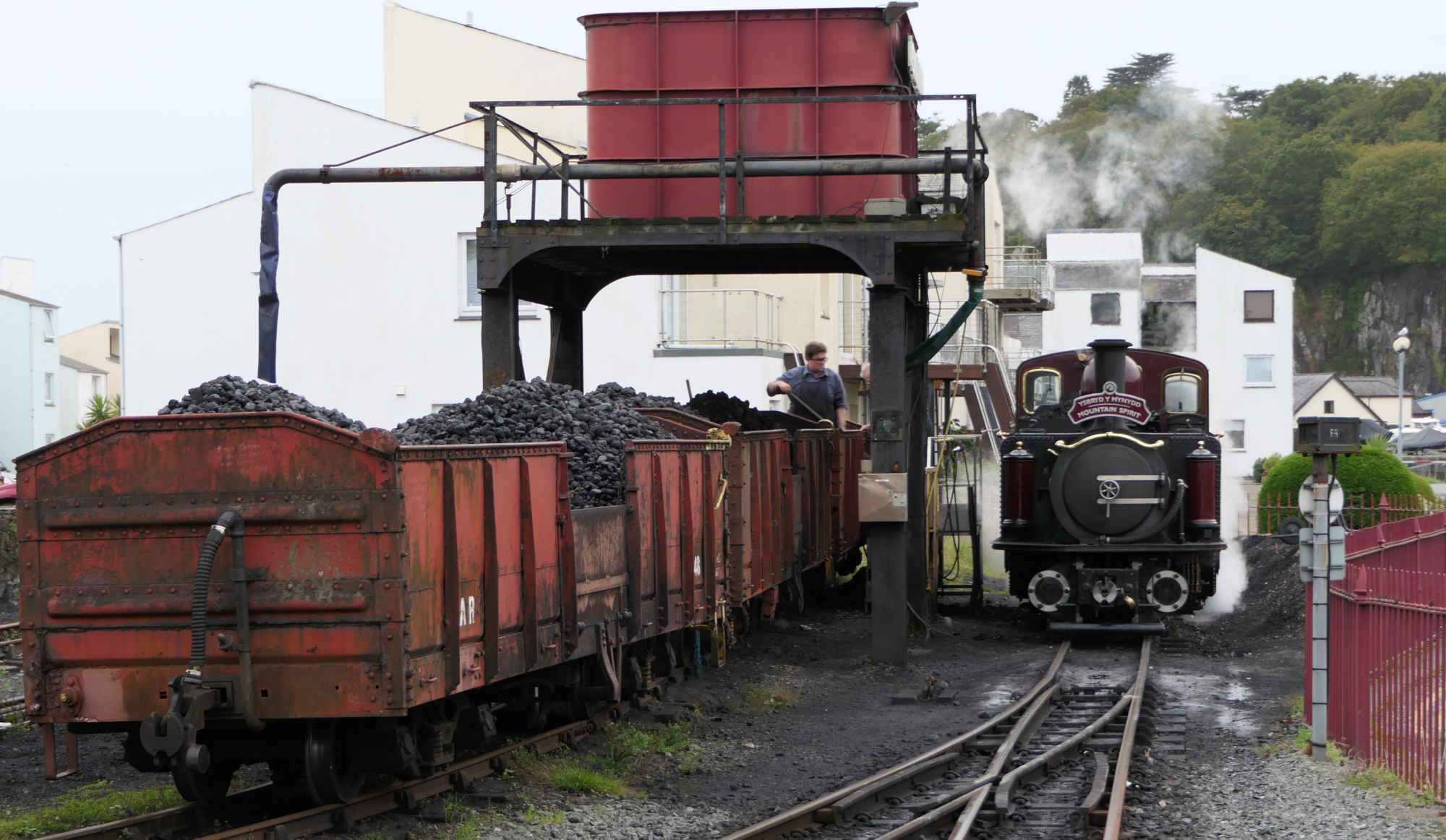 Steam train taking on coal at Porthmadoc station