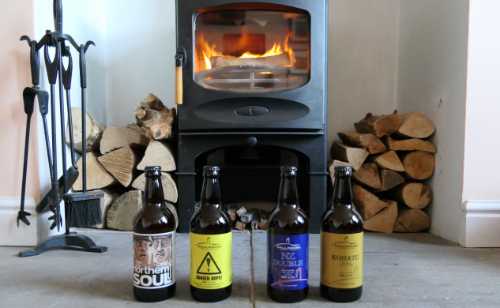 Four bottles of Mallinsons beer infront of our log burner