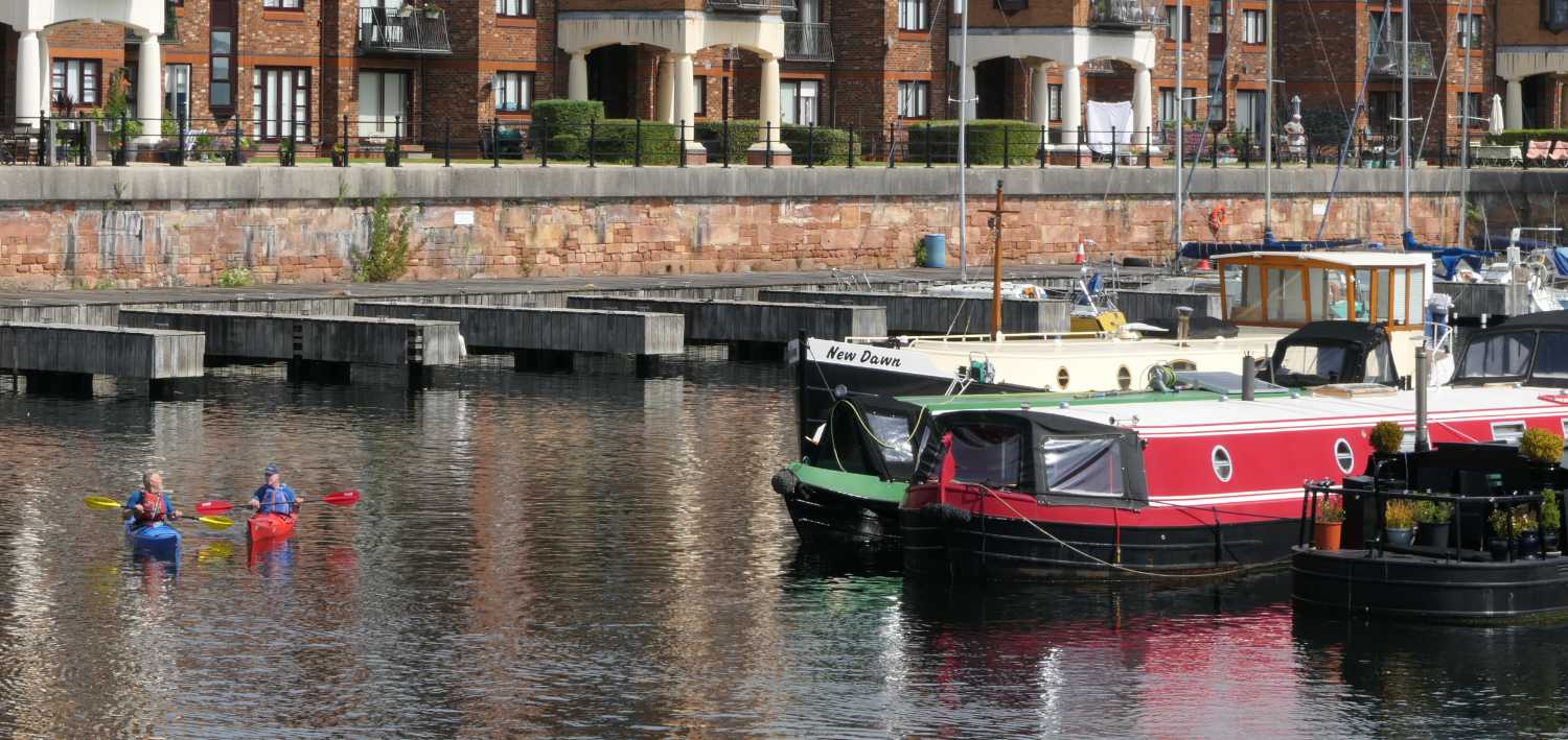 Canoes and narrow boats in the Brunswick Dock, two