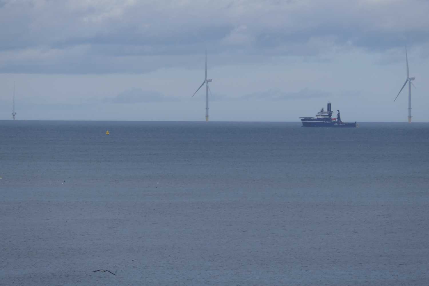 Boat and wind turbines far out at sea