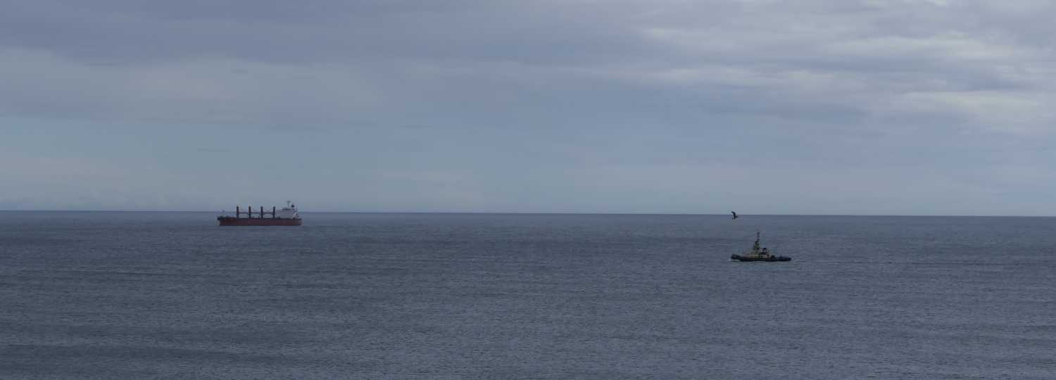Boat and tanker out at sea