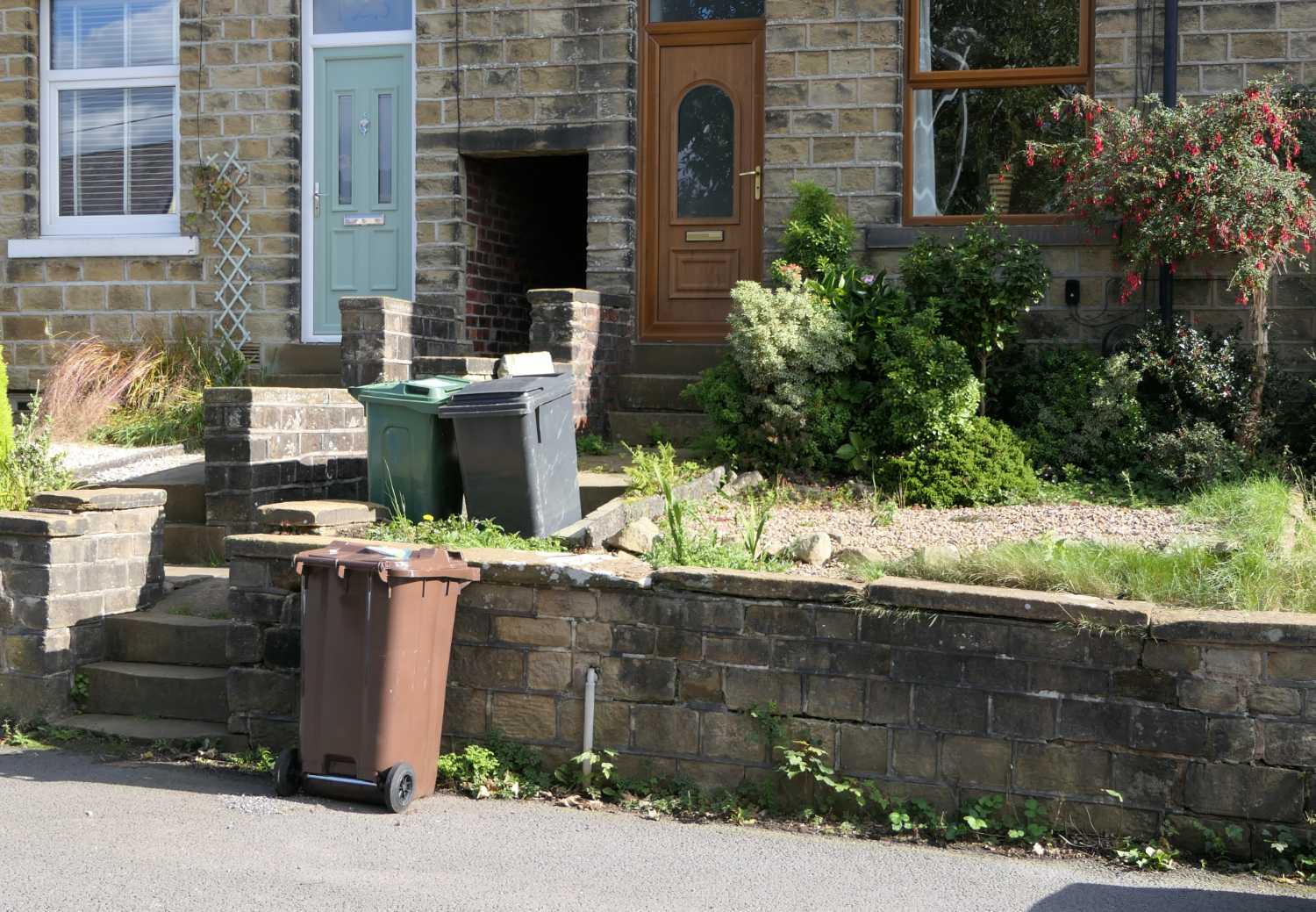 Brown bin outside house, one.