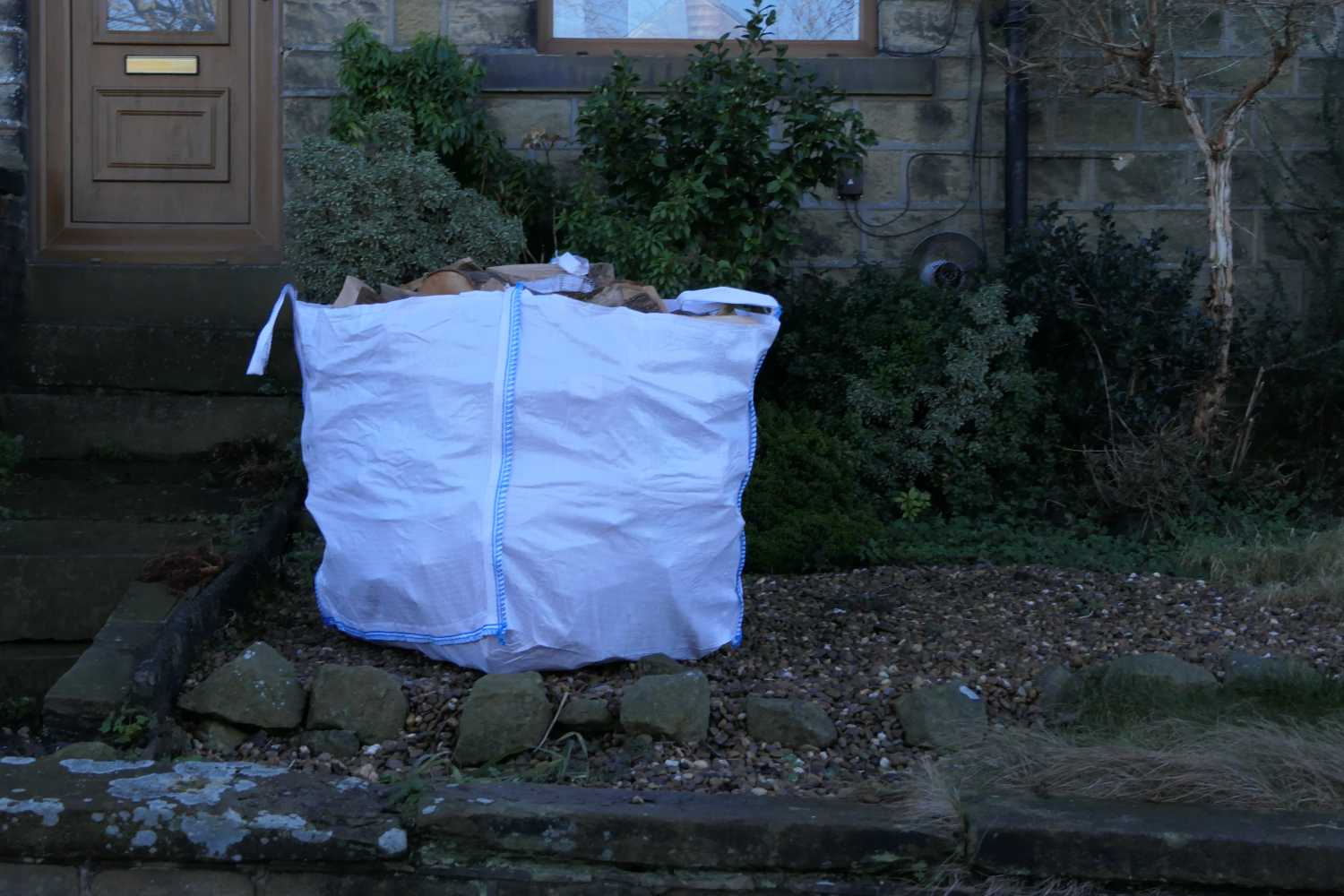 A builders bag of logs outside our house
