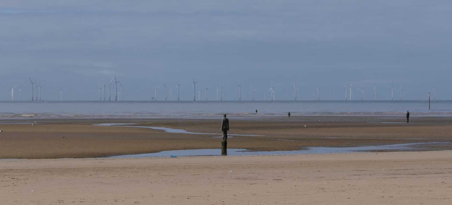 Gormley statues watching the Wirral cost wind farm